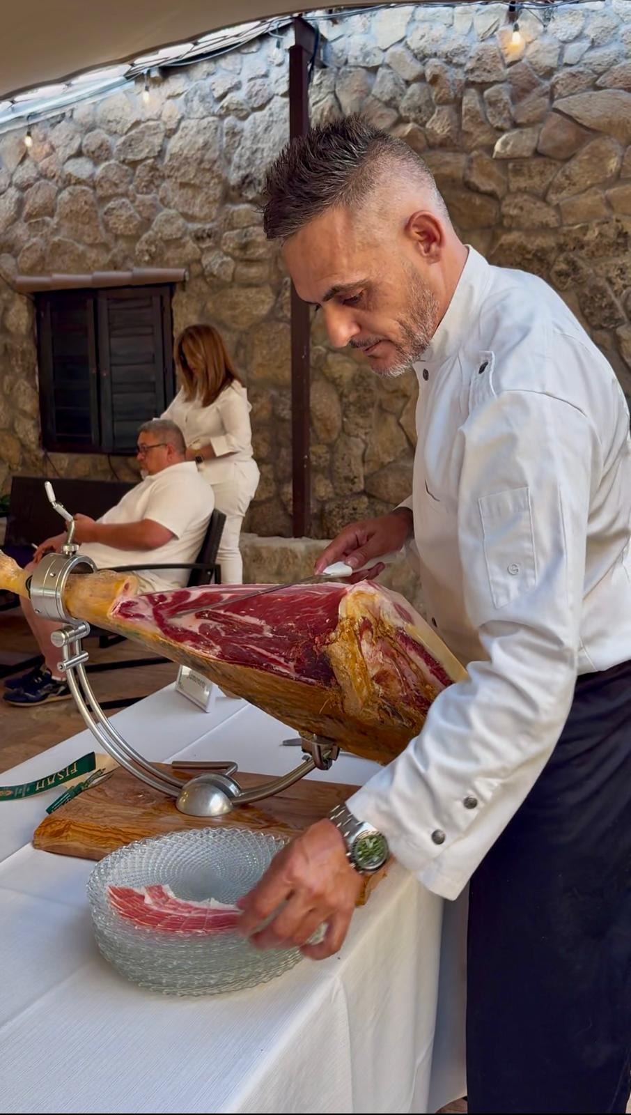 Miguel Ángel González cortando jamón ibérico en vivo durante un evento al aire libre