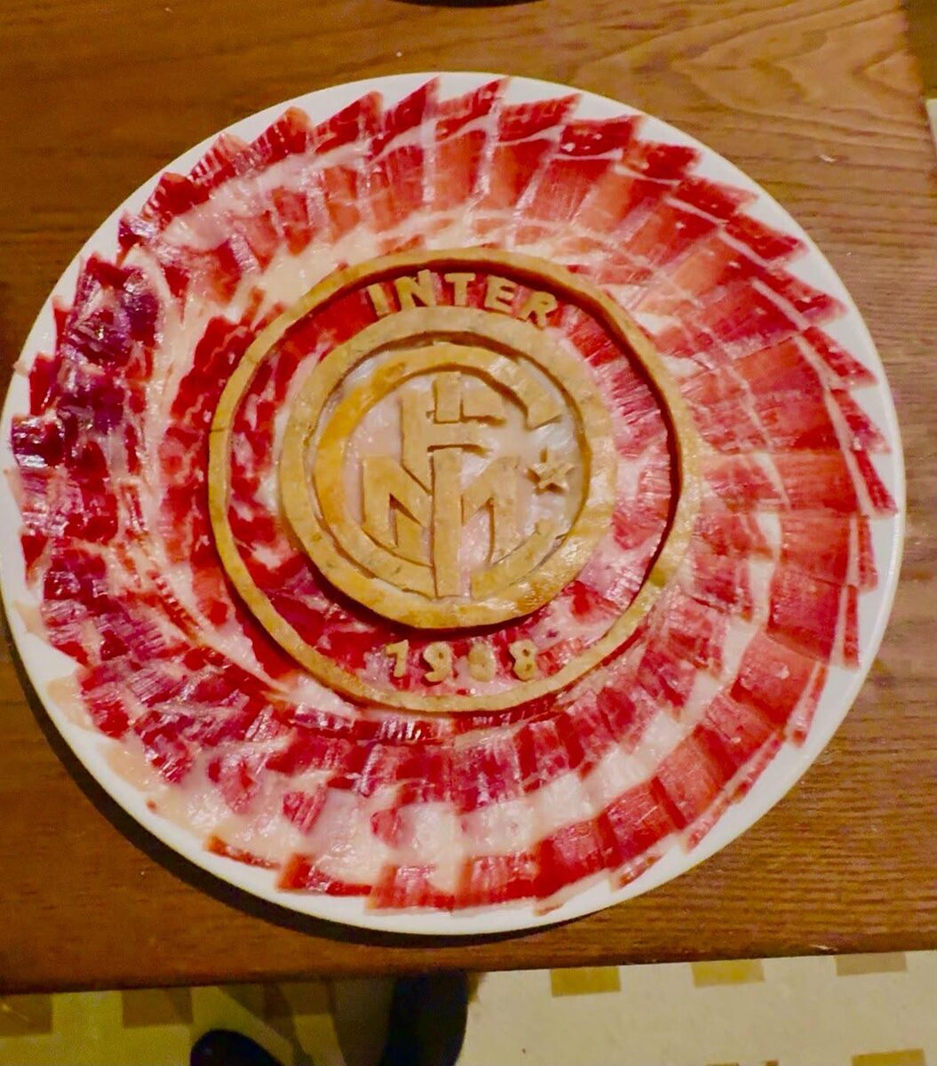 Miguel Ángel González junto a dos platos de jamón con escudos personalizados